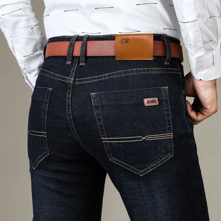 Herrjeans raka snitt i flexibel denim, blå och svart, visar bekvämlighet och stil för både arbete och fritid.