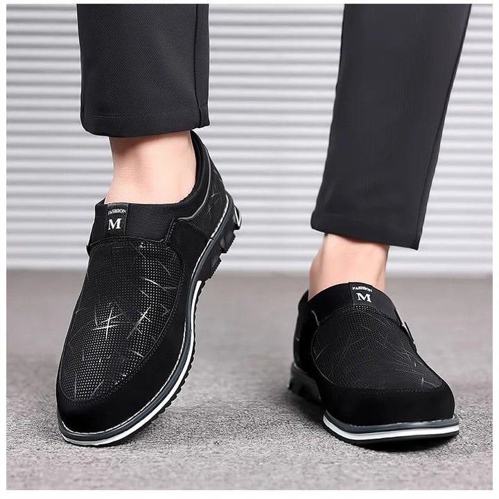 "Herrloafers i svart PU-läder med stilren slip-on-design, detaljerad sömnad och elegant plös för modern komfort."