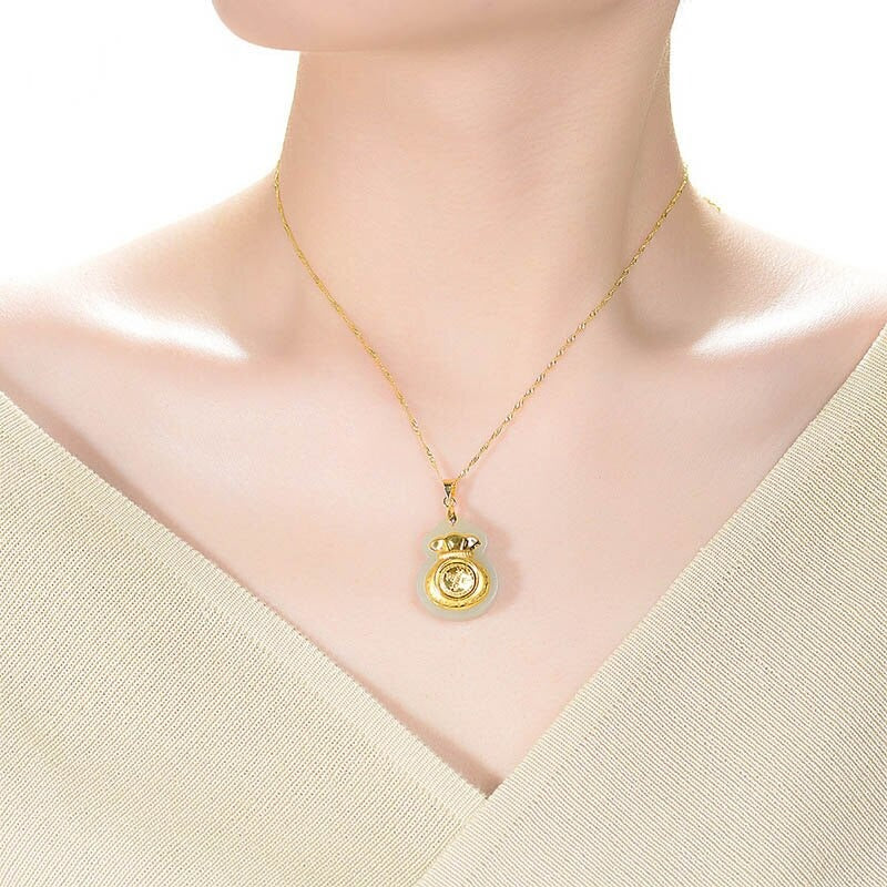 "Hängsmycke för kvinnor med Feng Shui inspiration, grön Hetian-jade och pengaväska symbol, i guldfärgad metall."