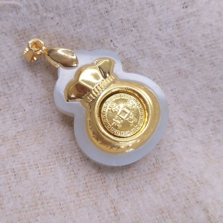 "Hängsmycke för kvinnor med Feng Shui inspiration, grön Hetian-jade och pengaväska symbol, i guldfärgad metall."