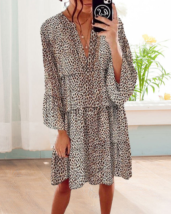 "Knielång kvinnoklänning med V-ringning och leopardsmönster, moderna puffärmar, elegant och djärv design."
