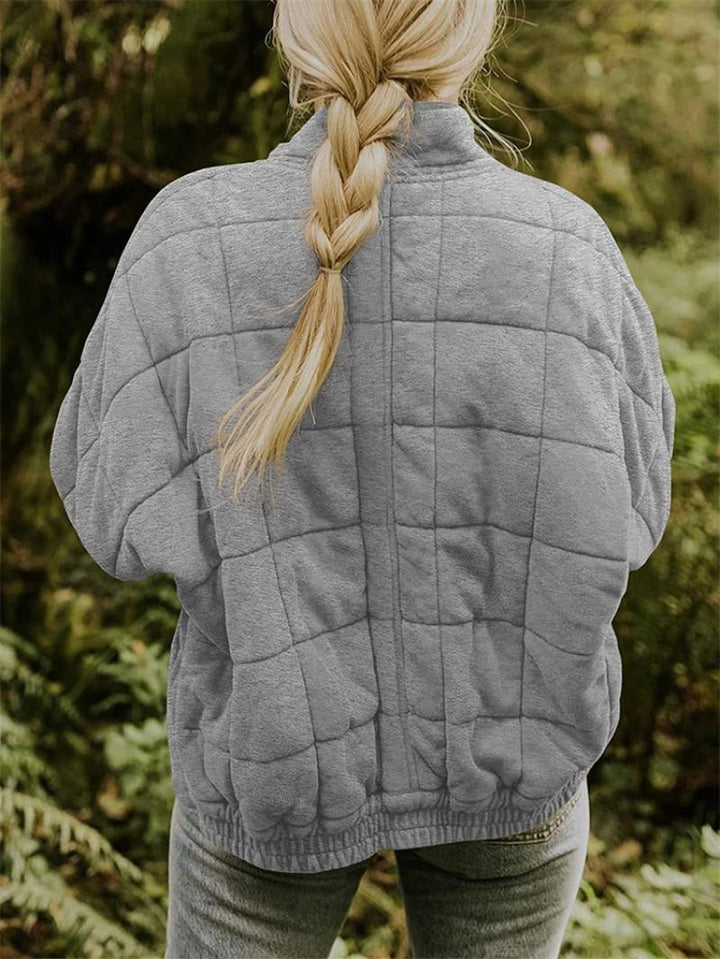 "Kviltad damjacka med elegant silhuett, perfekt vår/höst, i beige, blå eller grå. Stilren och tidlös design."