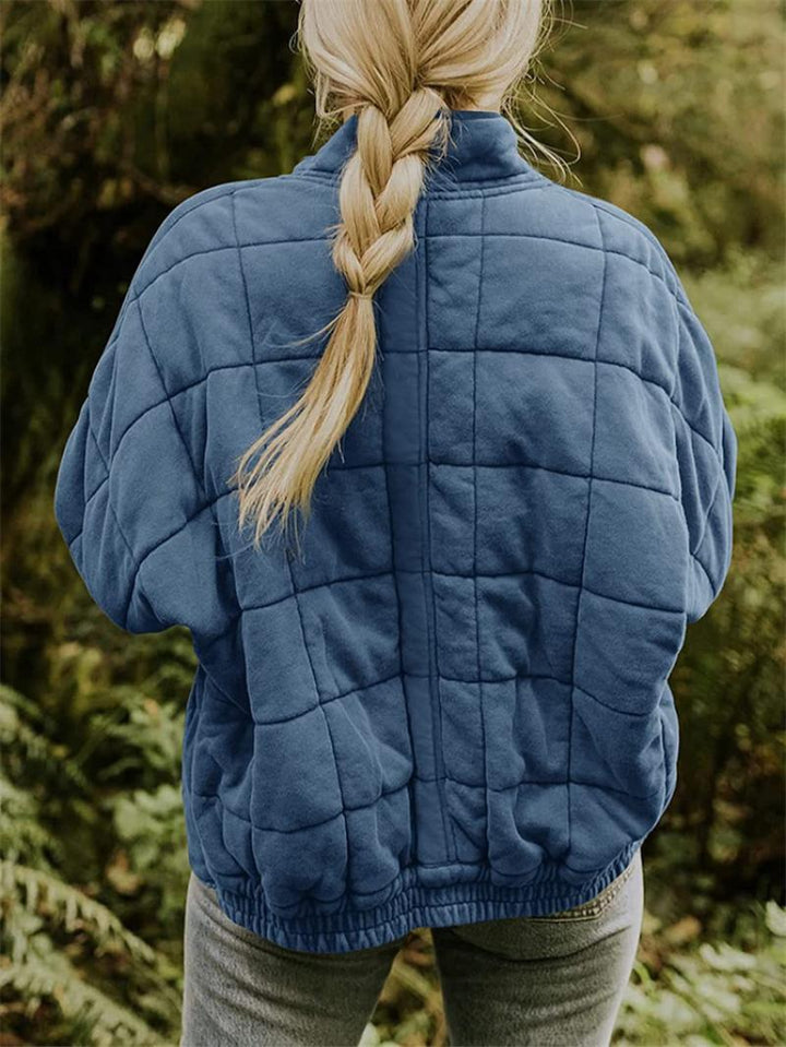 "Kviltad damjacka med elegant silhuett, perfekt vår/höst, i beige, blå eller grå. Stilren och tidlös design."