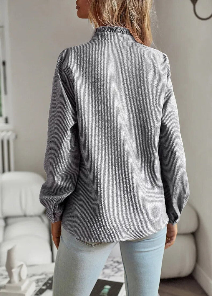 "Kvinna Ruffle Långärmad Skjorta i mjukt tyg, elegant feminin design med ruffle-detaljer, perfekt för olika tillfällen."
