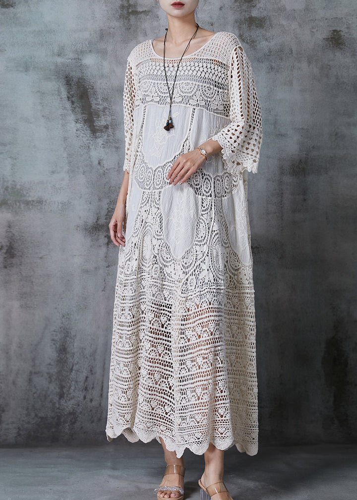 Kvinna i lång vit spetsklänning med romantisk oversized design, chic och bekväm för sommar eller kväll.
