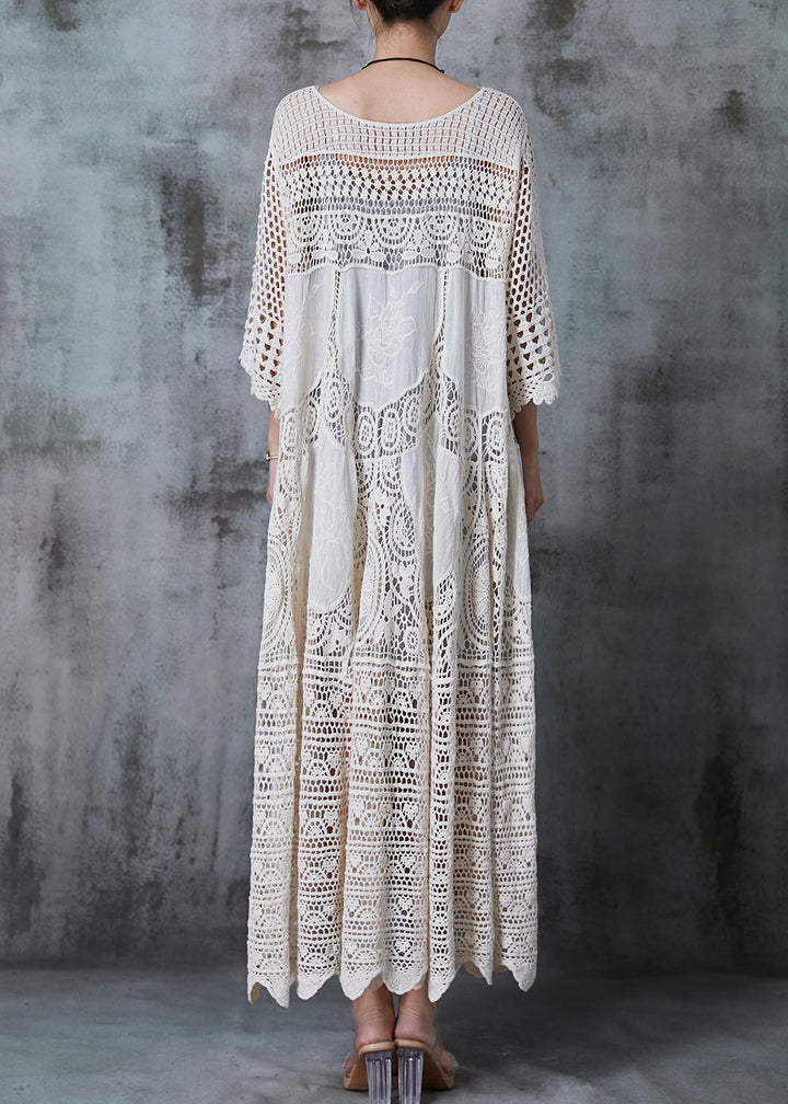 Kvinna i lång vit spetsklänning med romantisk oversized design, chic och bekväm för sommar eller kväll.