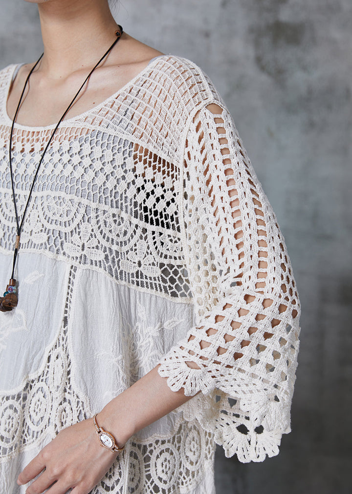 Kvinna i lång vit spetsklänning med romantisk oversized design, chic och bekväm för sommar eller kväll.