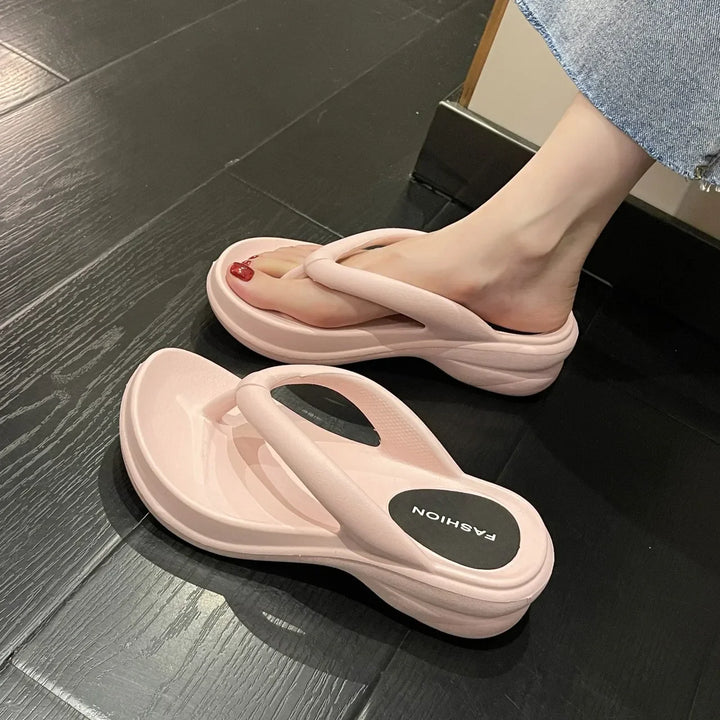 Damtofflor med kilklackar i vit, rosa och svart, slip-on modell perfekt för stranden och stadslivet.