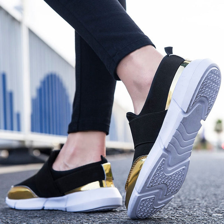 "Kvinnors andningsbara grå och svarta slip-on skor med modern design och stretchmaterial för bekväm daglig användning."