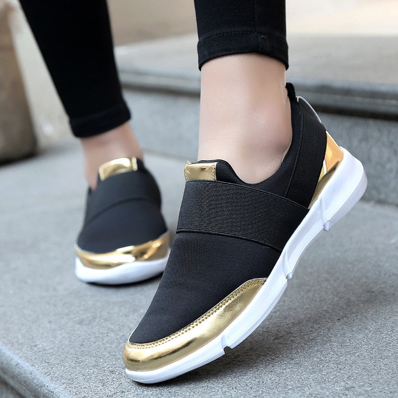 "Kvinnors andningsbara grå och svarta slip-on skor med modern design och stretchmaterial för bekväm daglig användning."