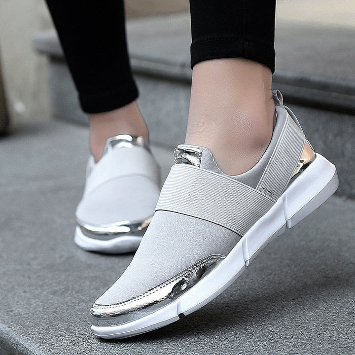 "Kvinnors andningsbara grå och svarta slip-on skor med modern design och stretchmaterial för bekväm daglig användning."
