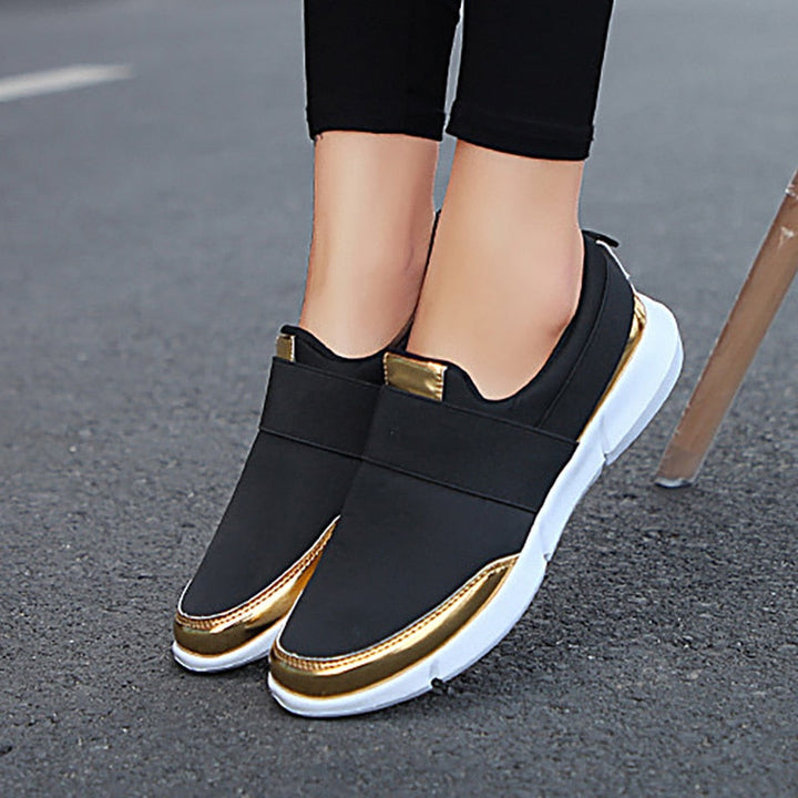 "Kvinnors andningsbara grå och svarta slip-on skor med modern design och stretchmaterial för bekväm daglig användning."