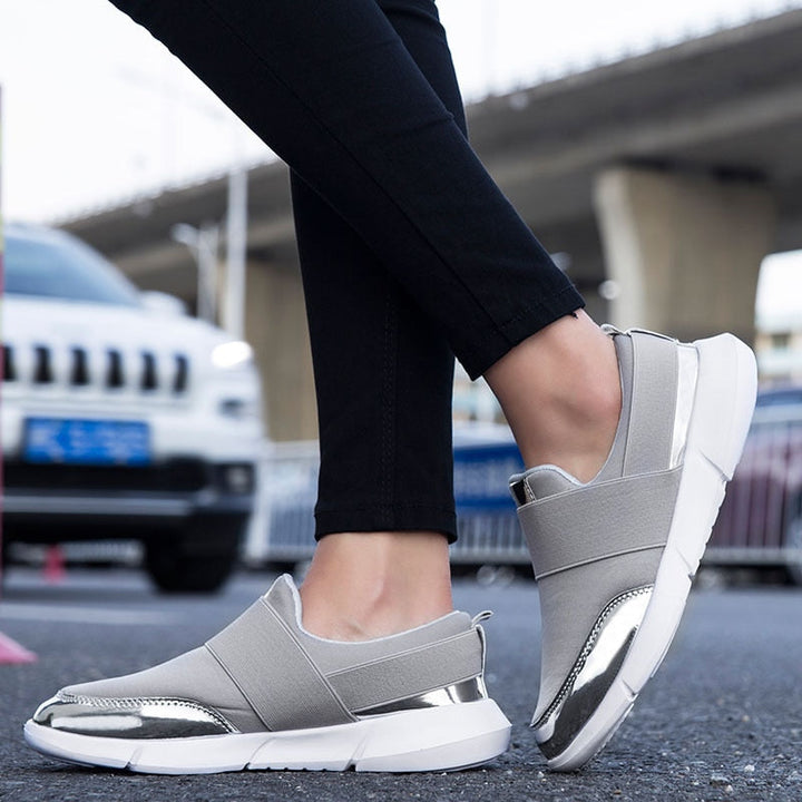 "Kvinnors andningsbara grå och svarta slip-on skor med modern design och stretchmaterial för bekväm daglig användning."