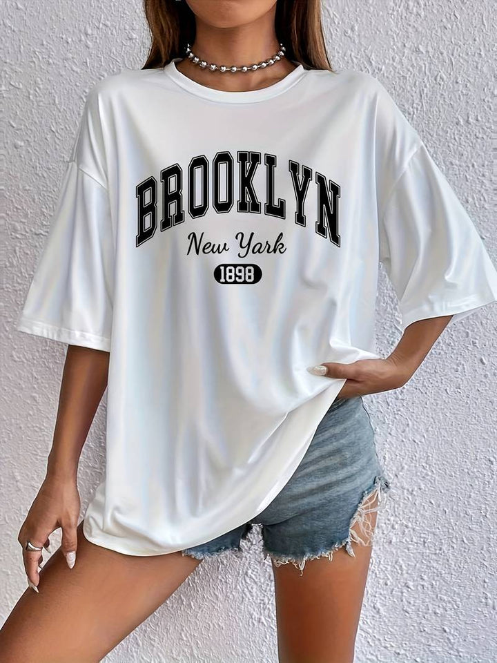 "Kvinnors bomulls-t-shirt med trendigt Brooklyn-tryck och cirkulär halsringning, avslappnad passform, vit färg."