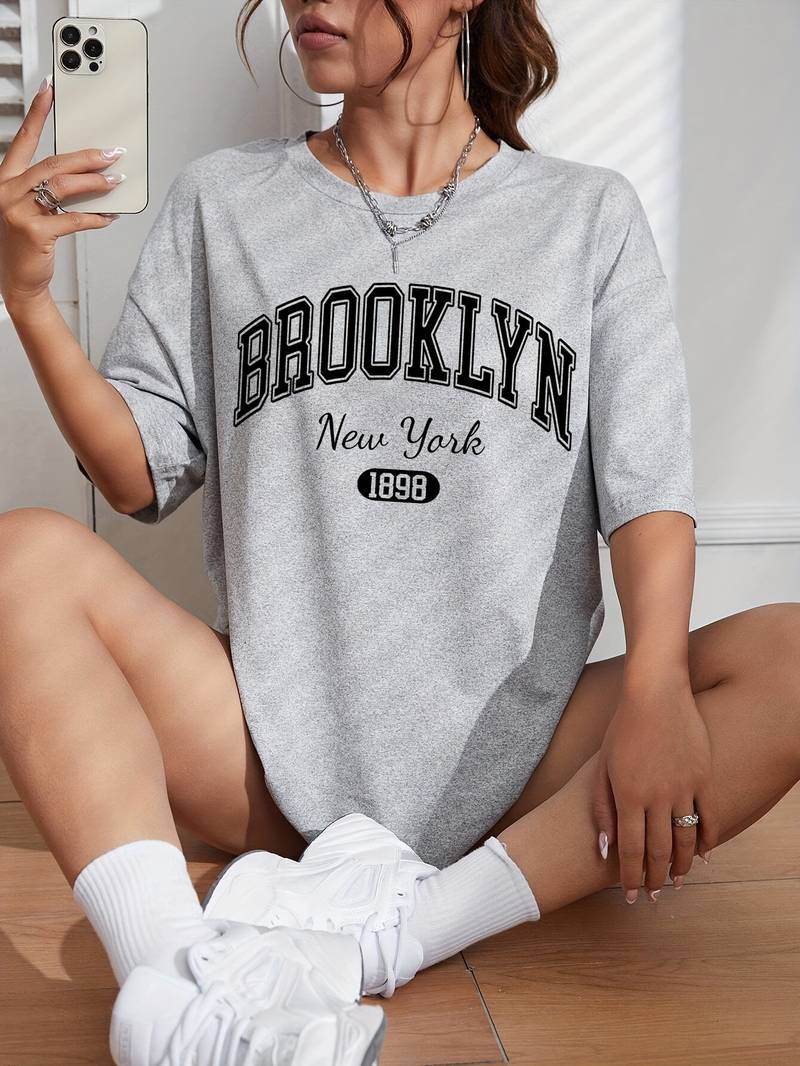 "Kvinnors bomulls-t-shirt med trendigt Brooklyn-tryck och cirkulär halsringning, avslappnad passform, vit färg."