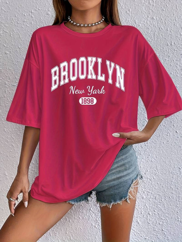 "Kvinnors bomulls-t-shirt med trendigt Brooklyn-tryck och cirkulär halsringning, avslappnad passform, vit färg."