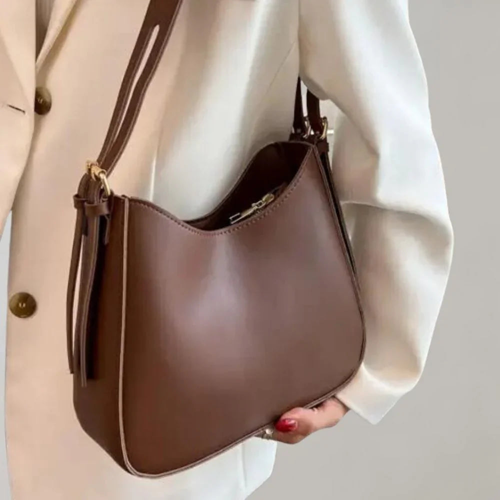 Dam Crossbody-väska med strukturerad design, guldaccenter, justerbar rem, elegant och funktionell för modern stil.