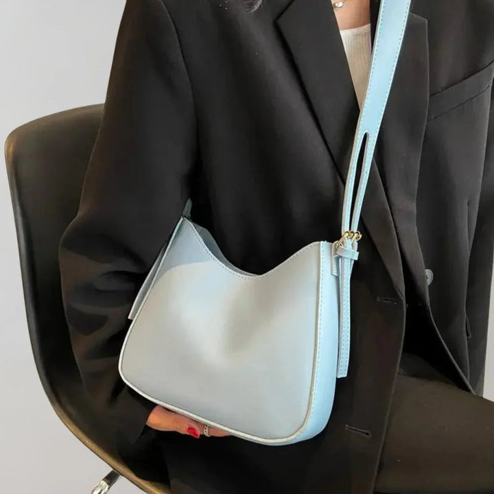 Dam Crossbody-väska med strukturerad design, guldaccenter, justerbar rem, elegant och funktionell för modern stil.