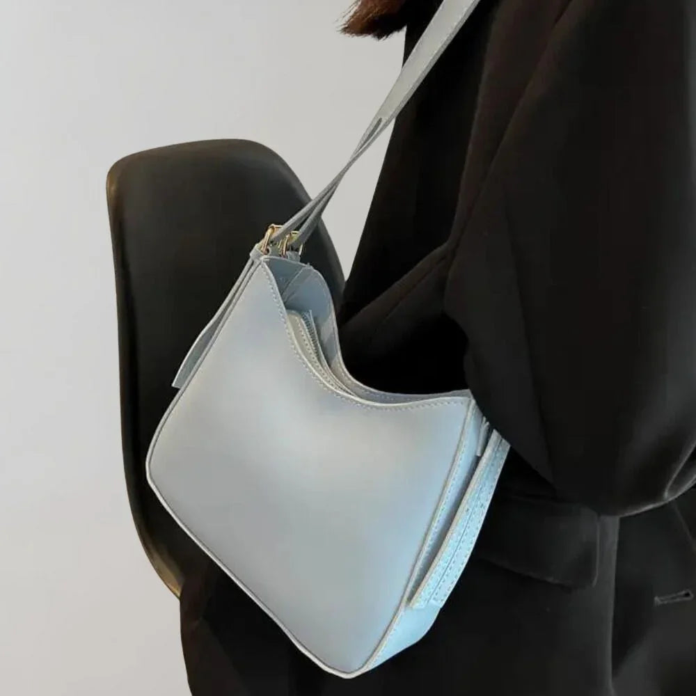Dam Crossbody-väska med strukturerad design, guldaccenter, justerbar rem, elegant och funktionell för modern stil.
