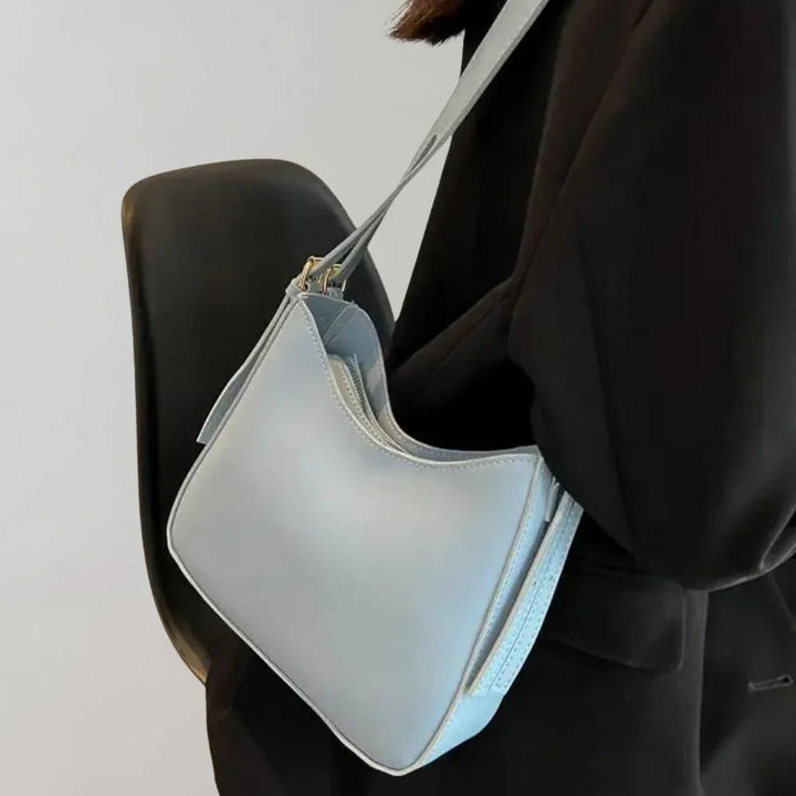 Dam Crossbody-väska med strukturerad design, guldaccenter, justerbar rem, elegant och funktionell för modern stil.