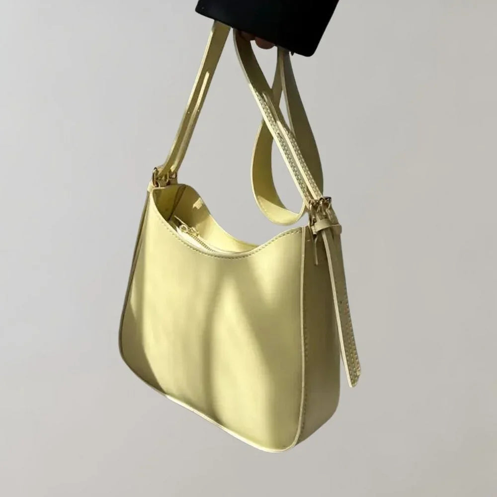 Dam Crossbody-väska med strukturerad design, guldaccenter, justerbar rem, elegant och funktionell för modern stil.