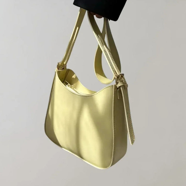 Dam Crossbody-väska med strukturerad design, guldaccenter, justerbar rem, elegant och funktionell för modern stil.