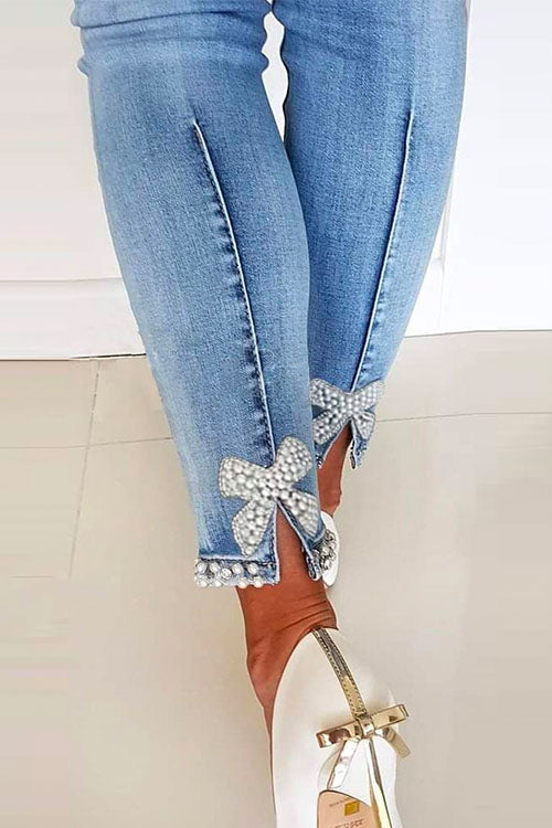 "Kvinnors denimbyxor med unik bågknut och pärldetaljer, formflatterande design, perfekt för alla tillfällen."