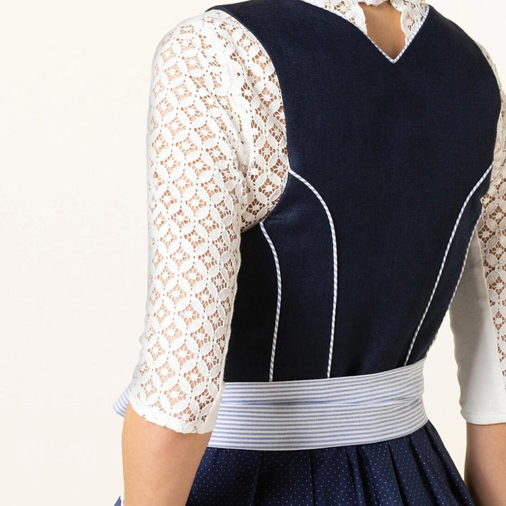 "Kvinnors dirndlklänning med blommönster, ärmlös design, axelband och glänsande schürze för festliga tillfällen."