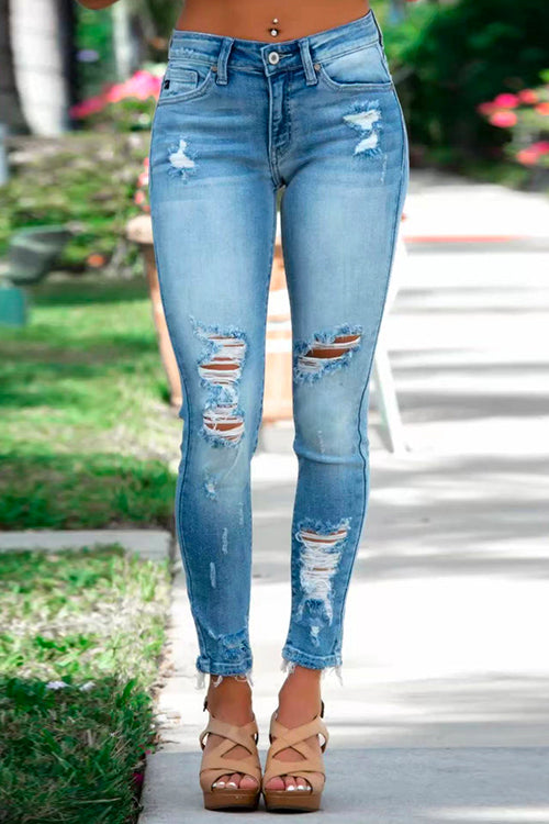 "Kvinnors distressade pencil jeans med rå fåll, ultrastretchig blå design för modern och edgy stil."