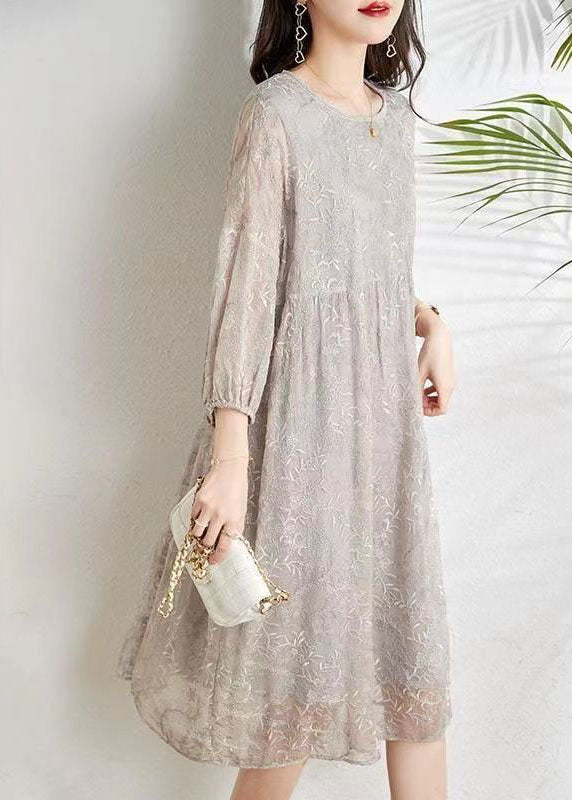 "Kvinnors elegant chiffonklänning med broderi och trekvartsärmar, visar chic design och smickrande passform."