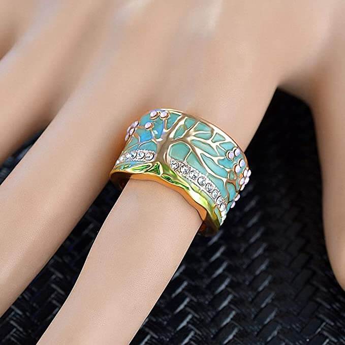 "Kvinnors elegant opalring med livets träd, i blått och grönt, symbol för styrka och stil, perfekt accessoar."