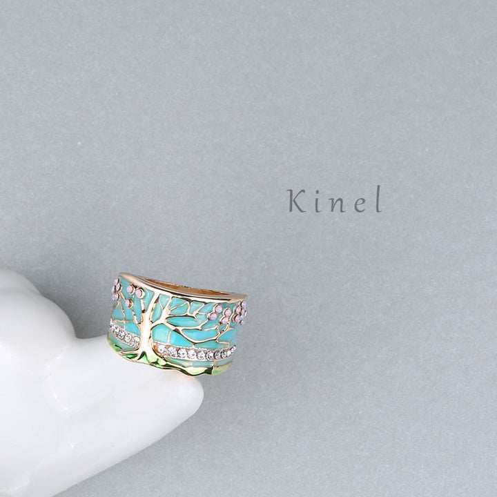"Kvinnors elegant opalring med livets träd, i blått och grönt, symbol för styrka och stil, perfekt accessoar."