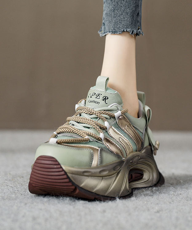 "Kvinnors guldfärgade plattformsskor med korsrem; elegant läderdesign med gummisula för stil och komfort."