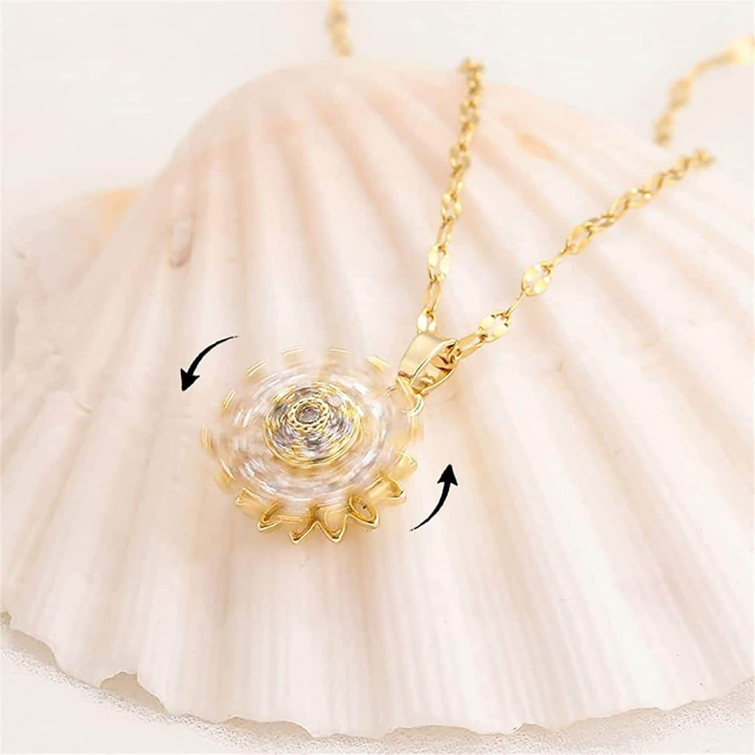 "Kvinnors halsband med snurrande solros i guld och silver, elegant symbol för vitalitet, solsken och modern stil."