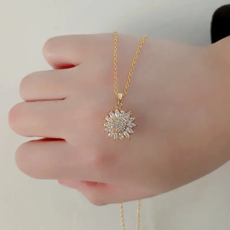 "Kvinnors halsband med snurrande solros i guld och silver, elegant symbol för vitalitet, solsken och modern stil."