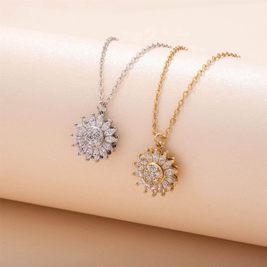"Kvinnors halsband med snurrande solros i guld och silver, elegant symbol för vitalitet, solsken och modern stil."
