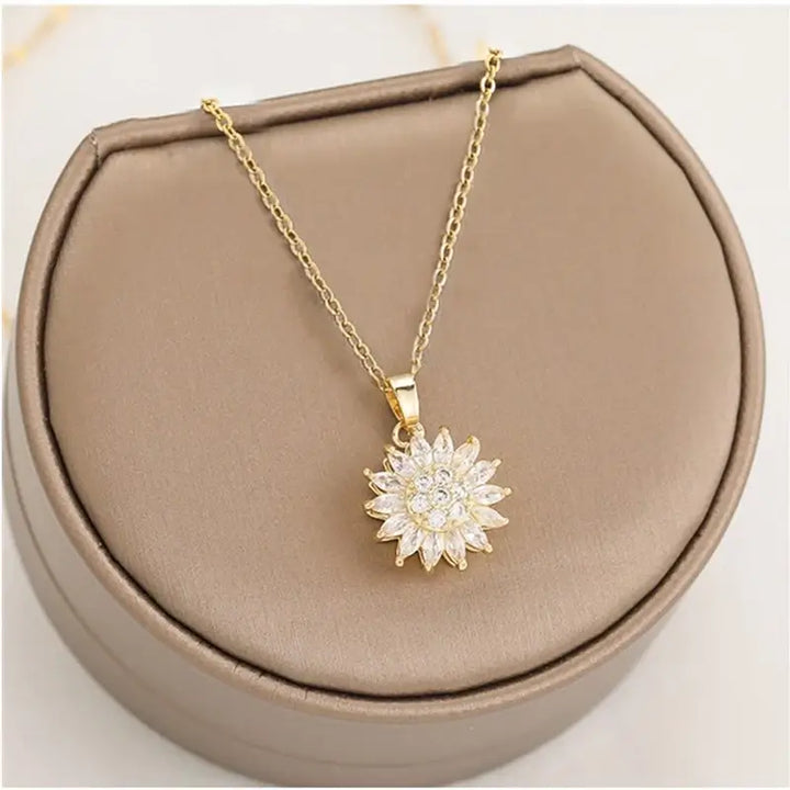 "Kvinnors halsband med snurrande solros i guld och silver, elegant symbol för vitalitet, solsken och modern stil."