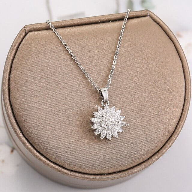 "Kvinnors halsband med snurrande solros i guld och silver, elegant symbol för vitalitet, solsken och modern stil."