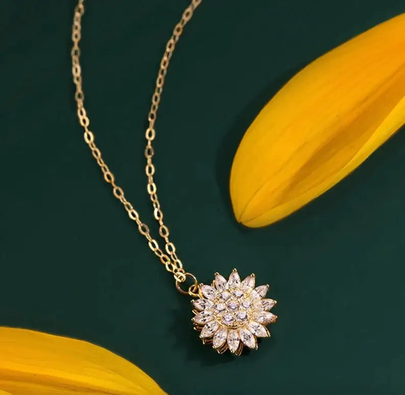"Kvinnors halsband med snurrande solros i guld och silver, elegant symbol för vitalitet, solsken och modern stil."