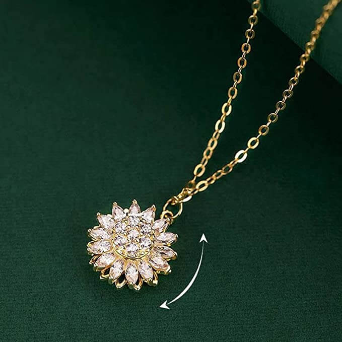 "Kvinnors halsband med snurrande solros i guld och silver, elegant symbol för vitalitet, solsken och modern stil."