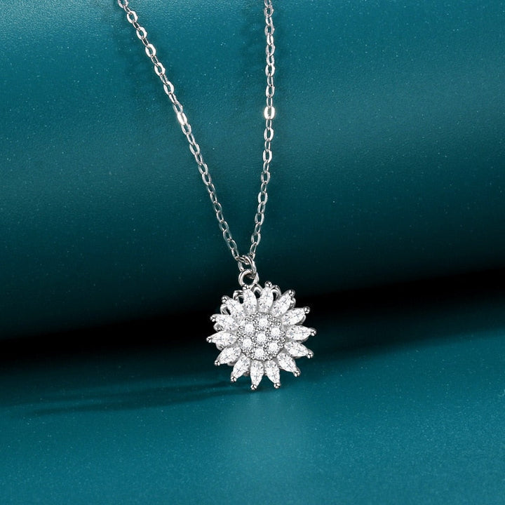 "Kvinnors halsband med snurrande solros i guld och silver, elegant symbol för vitalitet, solsken och modern stil."
