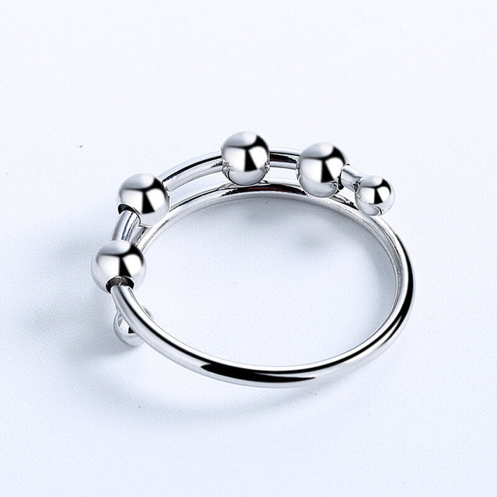 "Kvinnors justerbara fidget ring med pärlor, guld och silver, geometrisk design, lugnande accessoar mot stress."