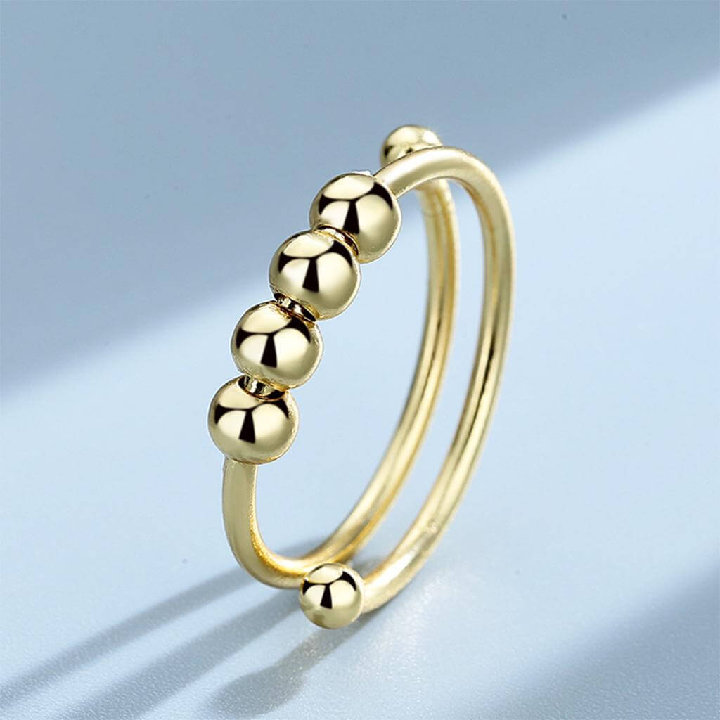"Kvinnors justerbara fidget ring med pärlor, guld och silver, geometrisk design, lugnande accessoar mot stress."