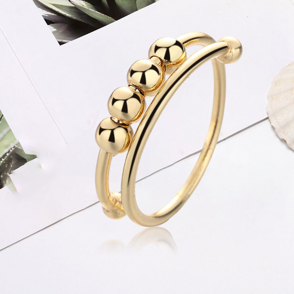 "Kvinnors justerbara fidget ring med pärlor, guld och silver, geometrisk design, lugnande accessoar mot stress."