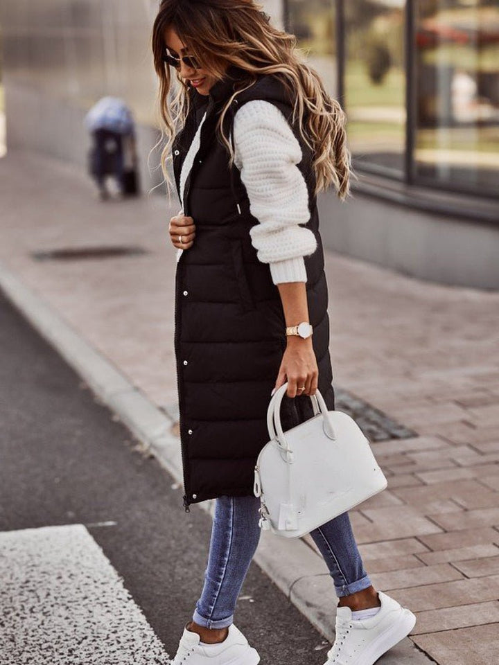 "Kvinnors knälång dunväst med elegant steppdesign, lätt och bekväm, perfekt för kyliga dagar och trendiga outfits."