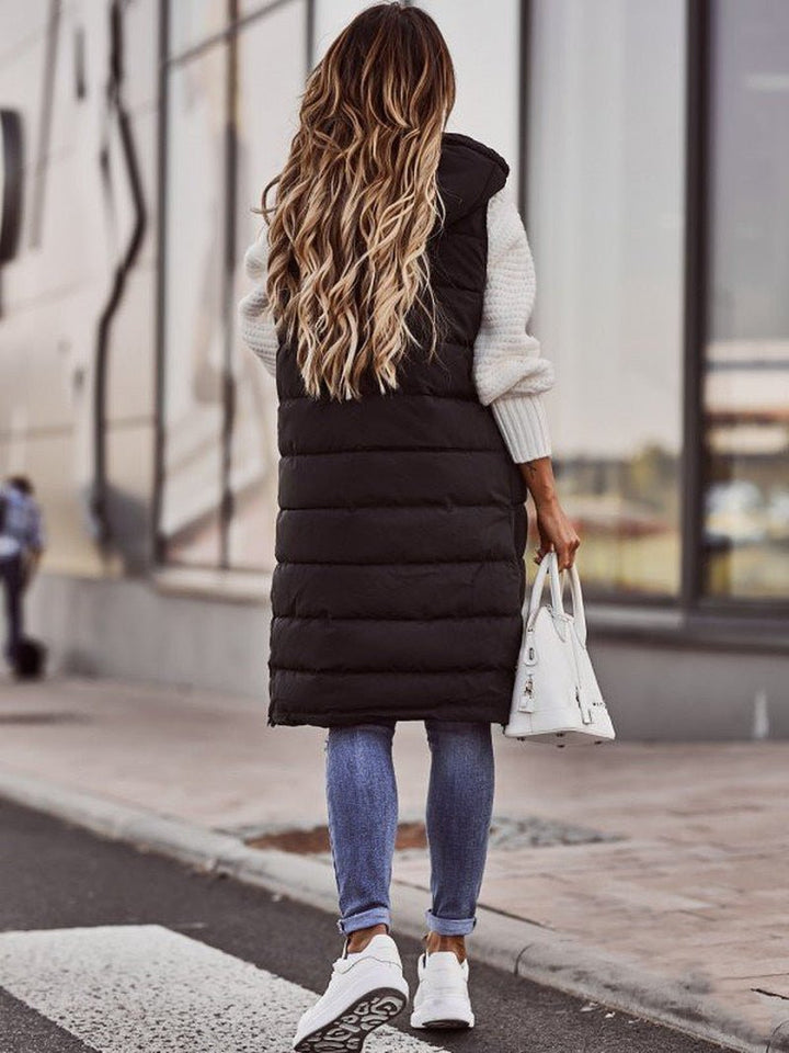 "Kvinnors knälång dunväst med elegant steppdesign, lätt och bekväm, perfekt för kyliga dagar och trendiga outfits."