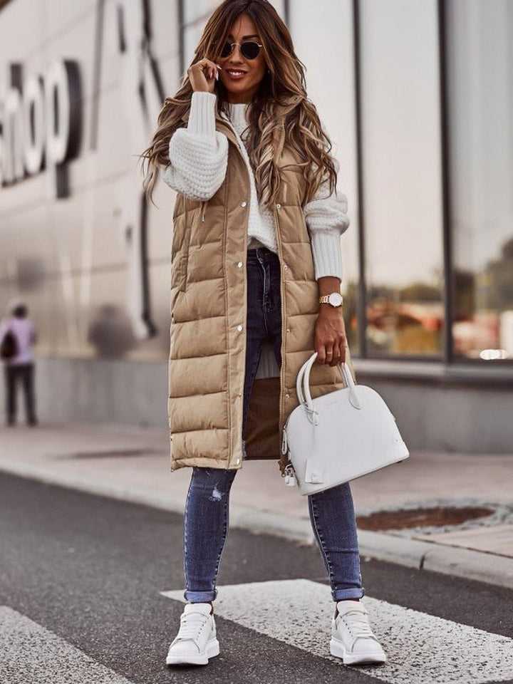 "Kvinnors knälång dunväst med elegant steppdesign, lätt och bekväm, perfekt för kyliga dagar och trendiga outfits."