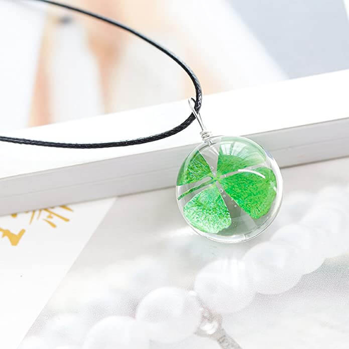 "Kvinnors kristallhalsband med fyrklöver berlock i klar harts, elegant konstläderkedja som symboliserar tur och charm."