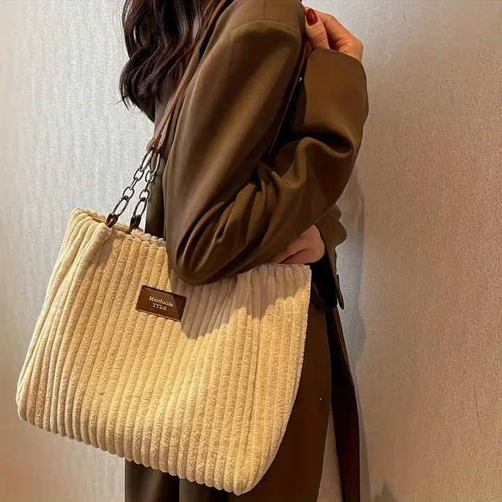 "Kvinnors rymlig corduroy handväska i mjuk beige med minimalistisk design och justerbar rem."