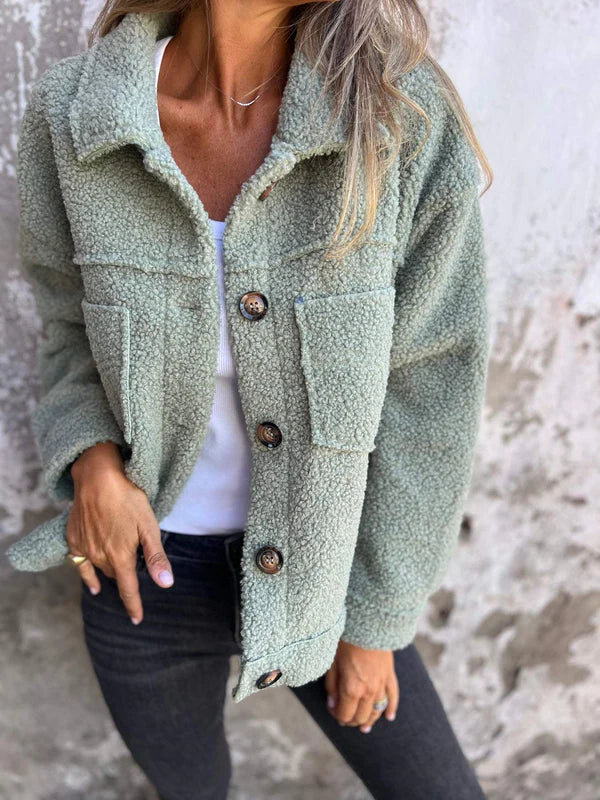 "Kvinnors sherpa-jacka med knäppning och stora fickor, mjuk plysch och elegant stil, idealisk för höst och vinter."